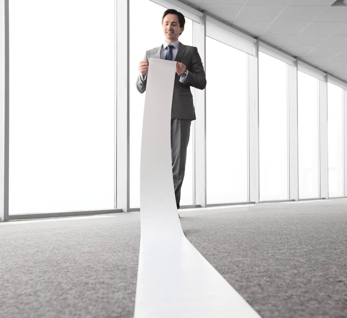 man with long piece of paper that is dragging on the ground