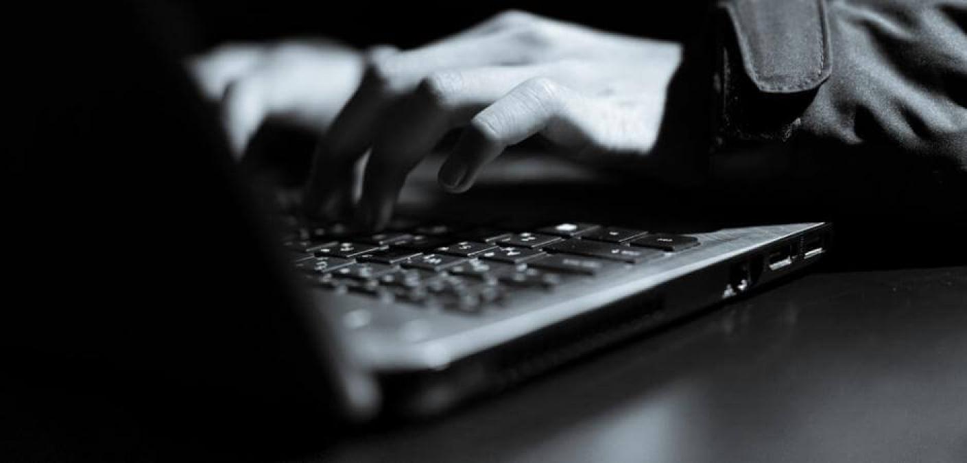 man typing on laptop