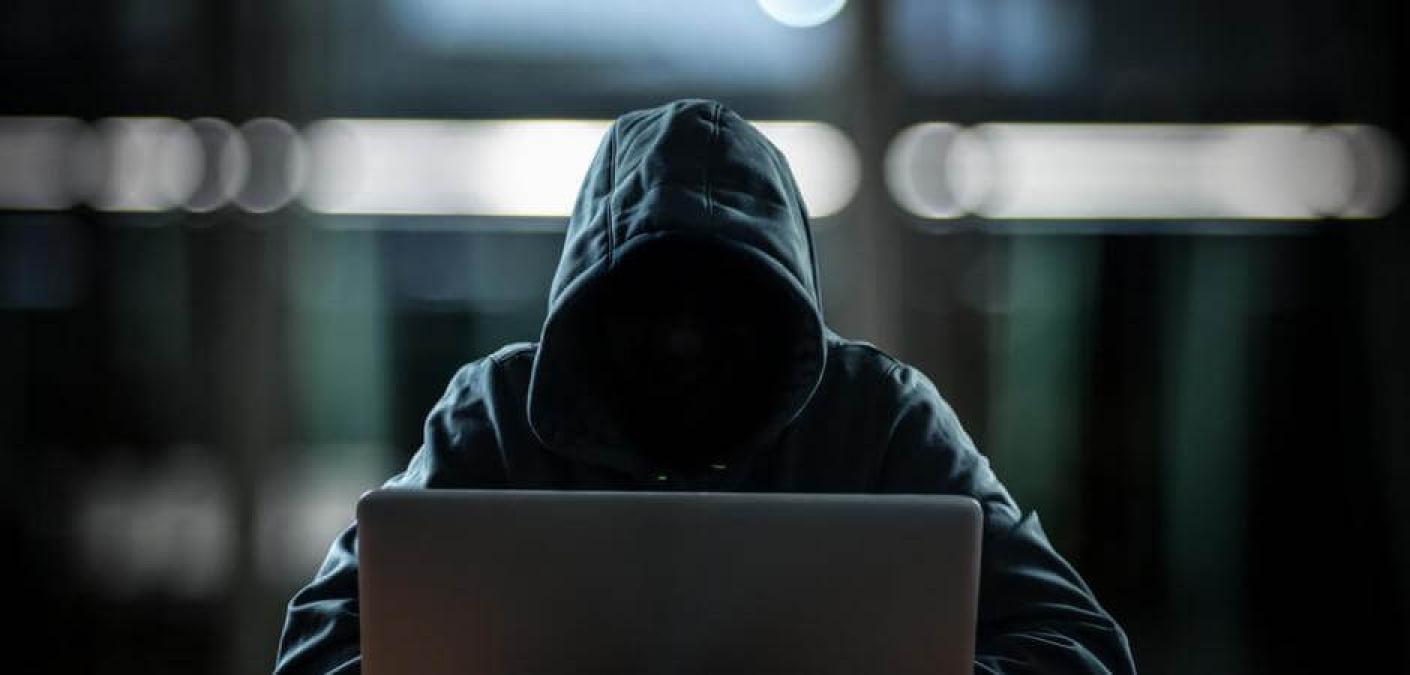 person in hoodie on laptop