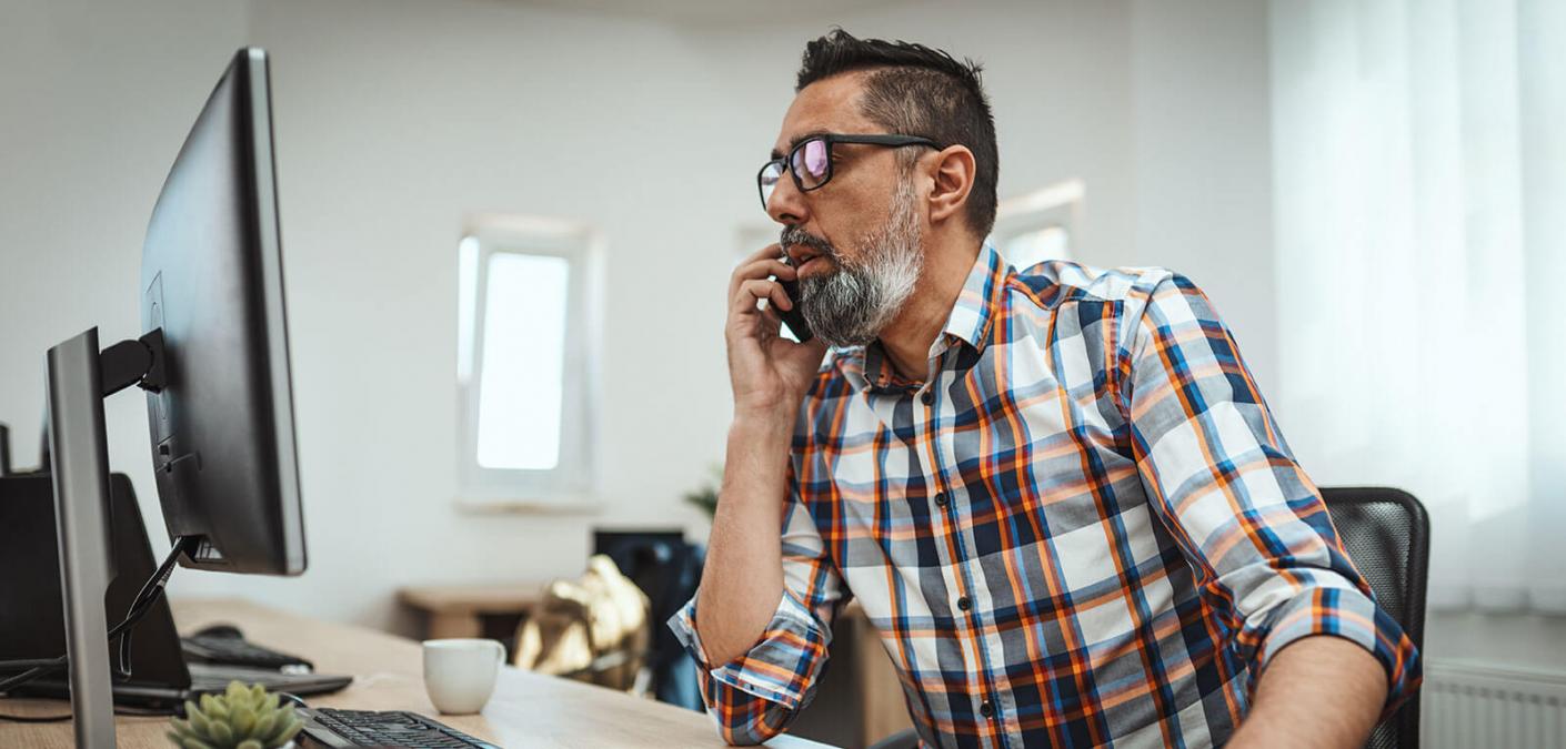 man on phone using computer