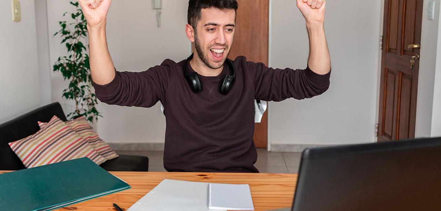 man at desk raising his fists