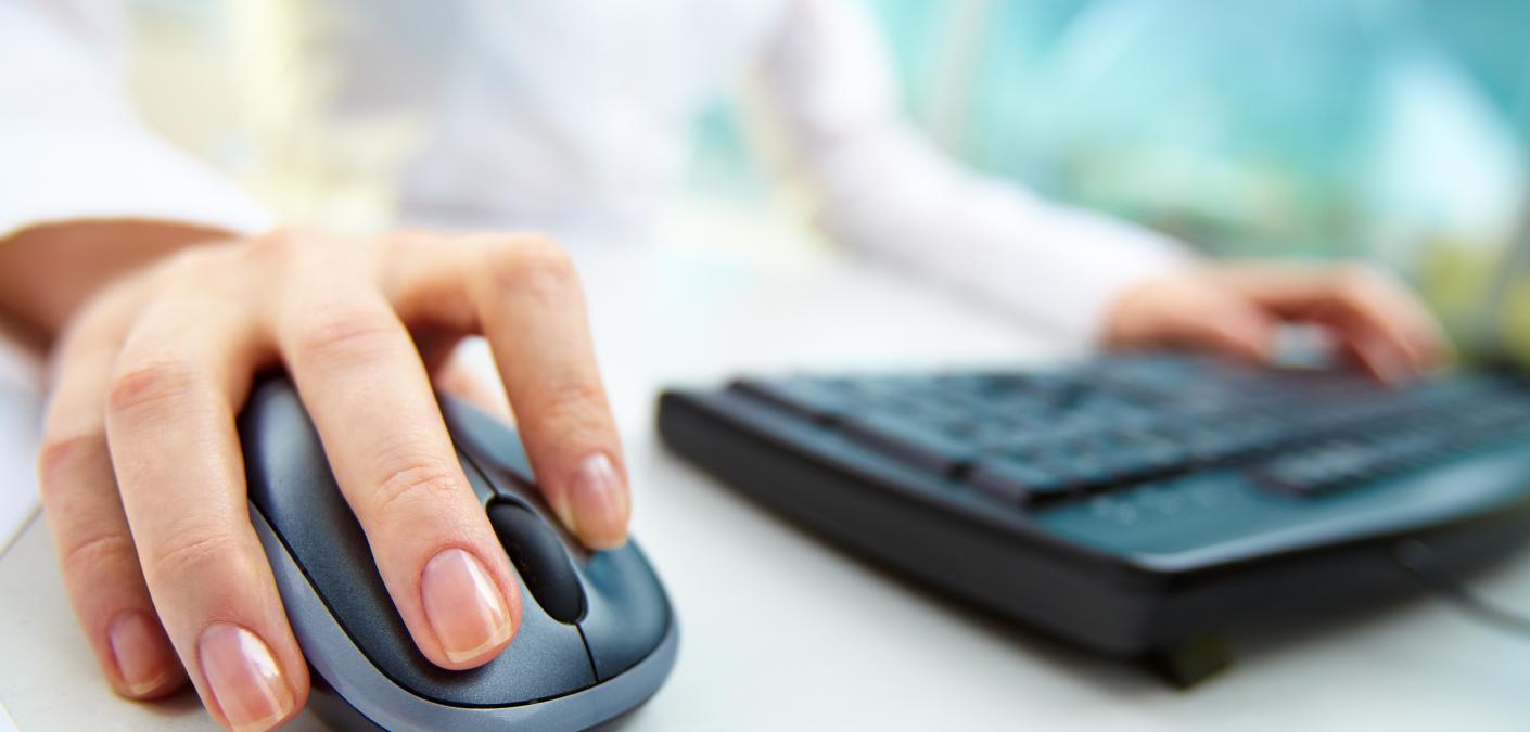 woman's hand on mouse and keyboard